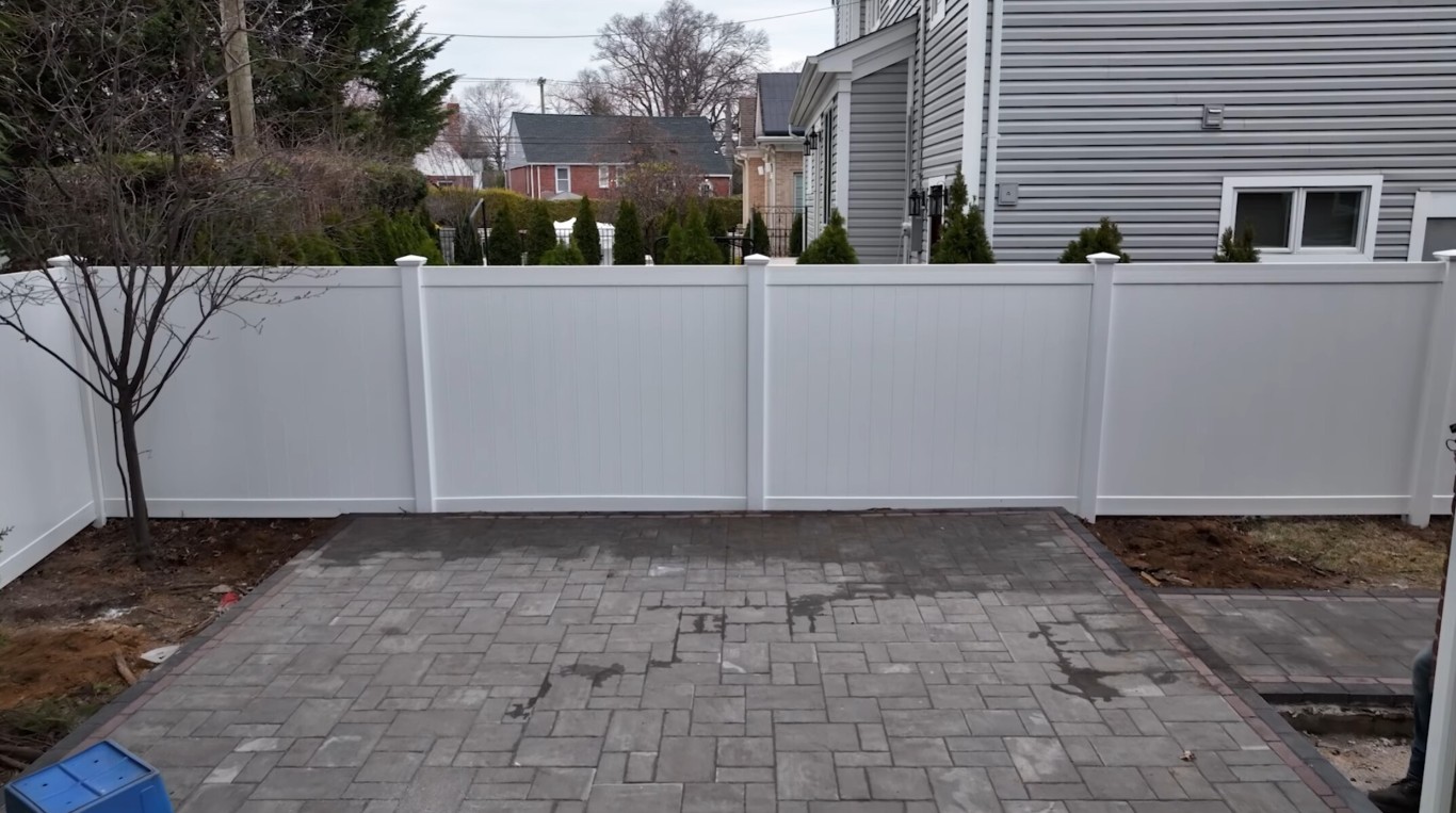 Solid white vinyl privacy fence installation for residential security